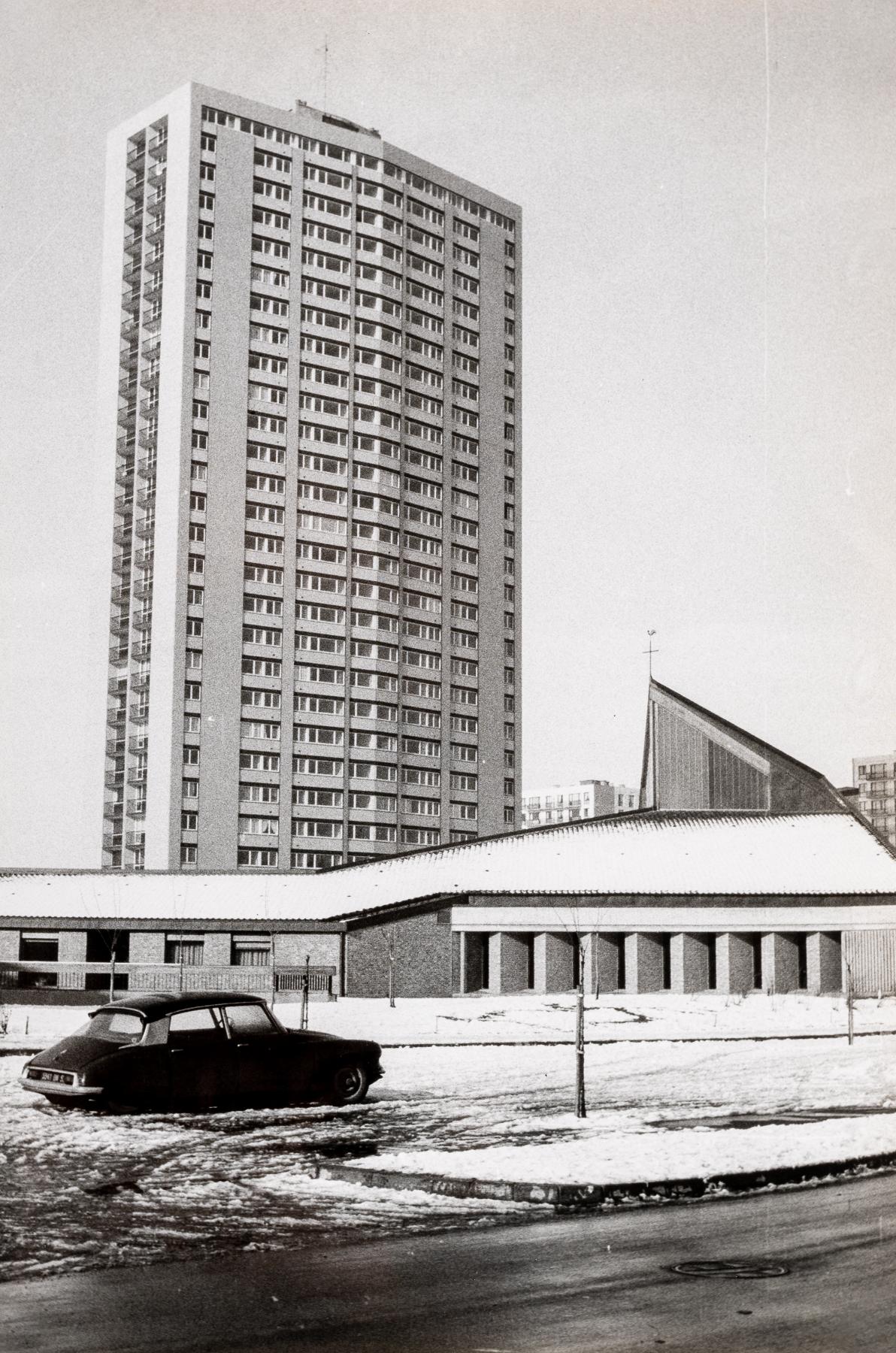 La tour Kennedy (façade est) peu après son édification, vue depuis la rue Albert-Châtelet. Au premier plan l'église catholique de la Sainte-Trinité (AC Loos-les-Lille ; 1 Fi 849).